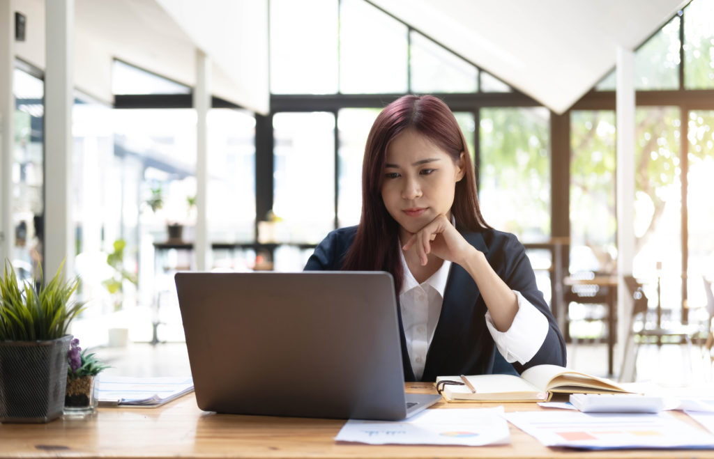 Woman working on laptop researching how to switch IT Support Providers