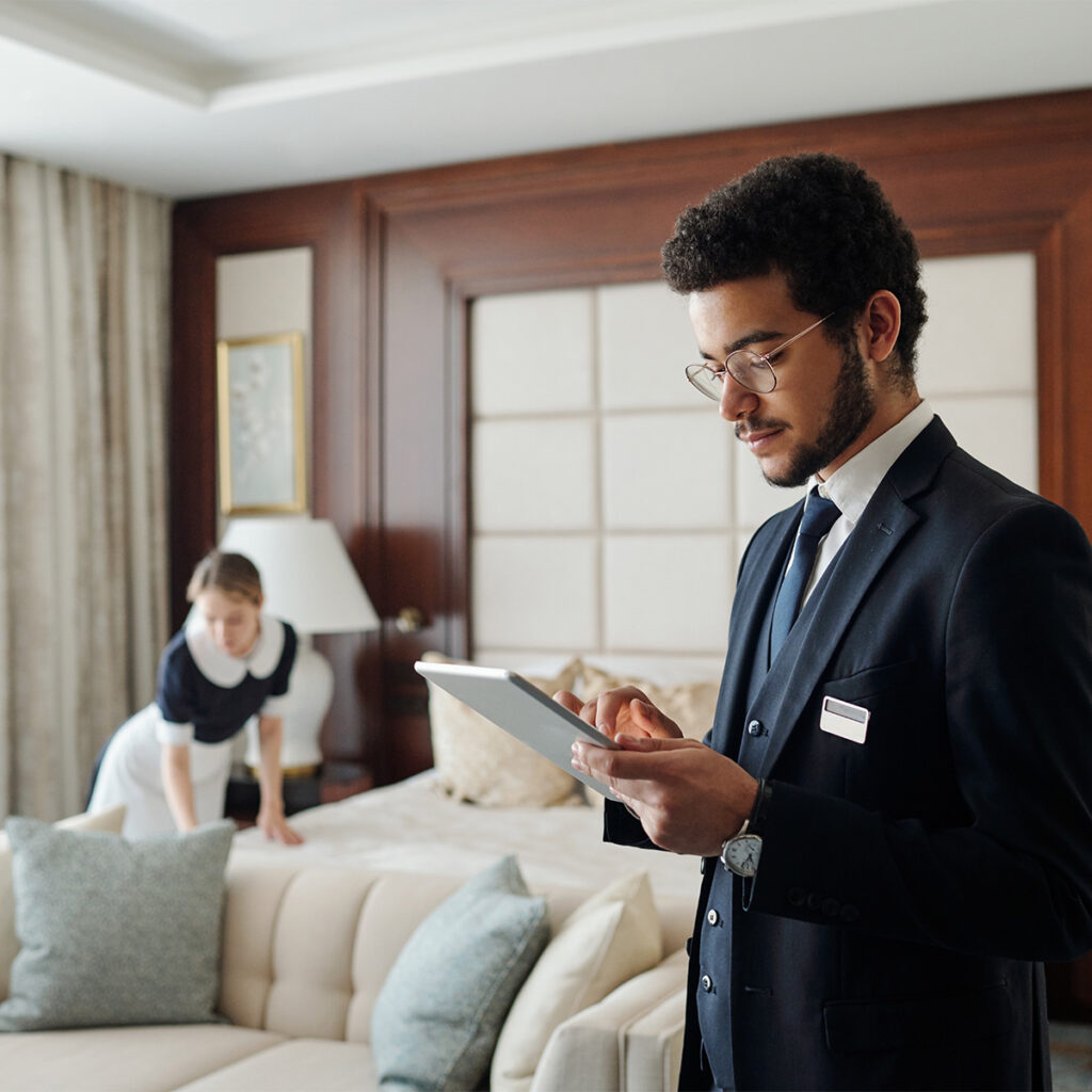 hotel employee using a secure tablet device in a guest room