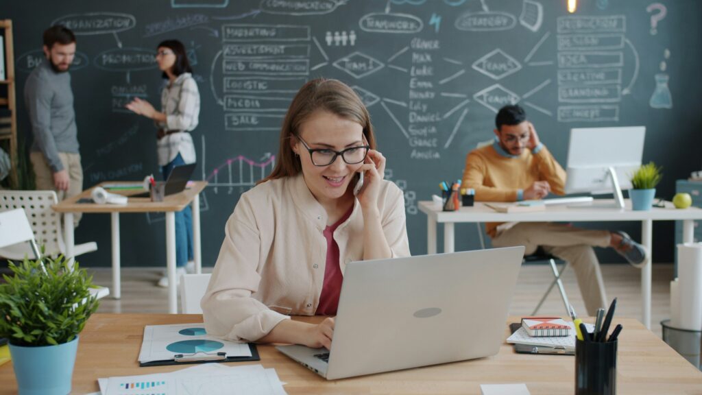 Woman on the phone with IT Support with a pleased expression